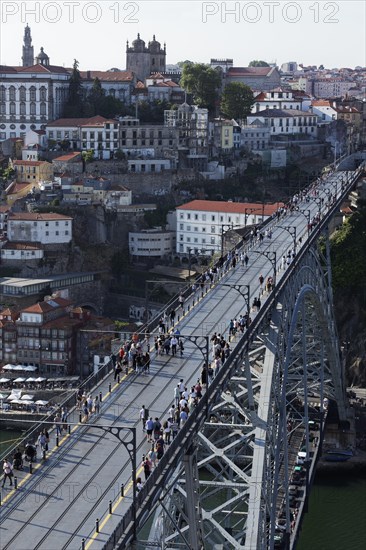 Pedestrians walking across the upper deck of the Ponte D. Luis I