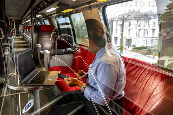 Business Woman Working on Laptop in First Class in a Train in Switzerland