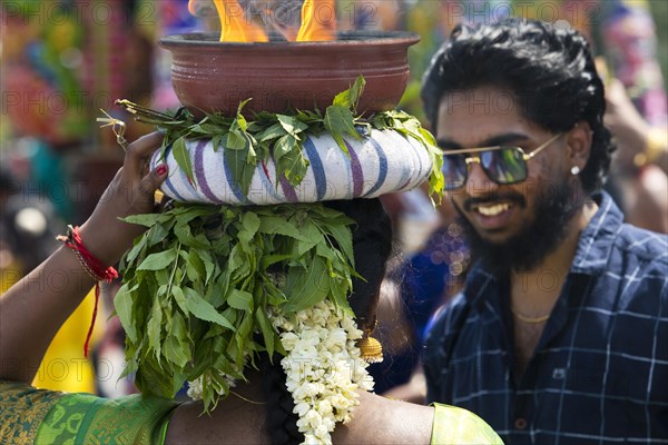 A Hindu woman carries a fire bowl during the big procession Theer