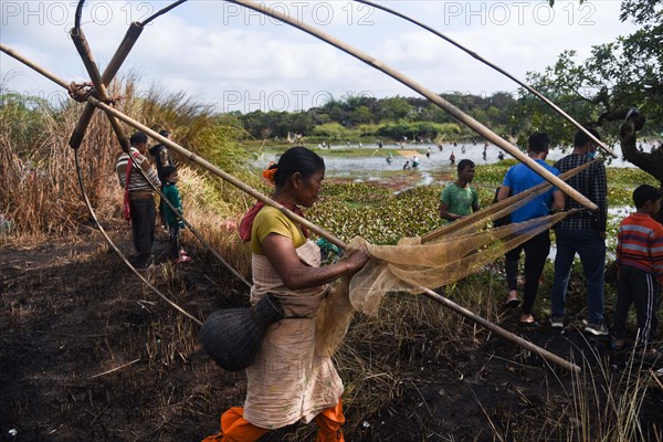 Villagers participate in a community fishing event on the occasion of Bhogali Bihu Festival at Goroimari Lake in Panbari village