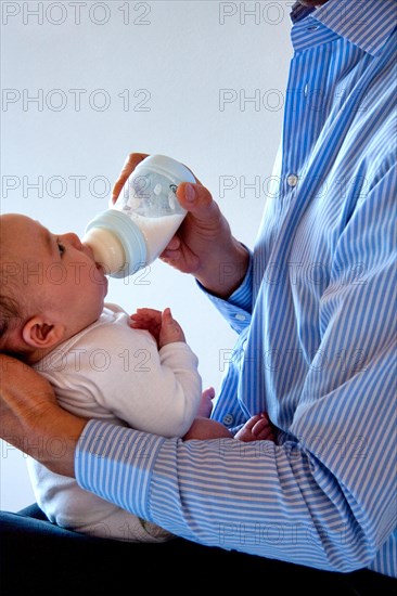 Father feeding his newborn baby