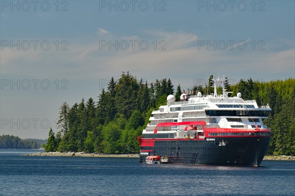 A Hurtigruten expedition ship lies in a small bay