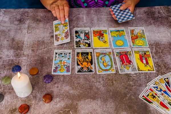 Woman reading tarot cards with candles and chakra stones