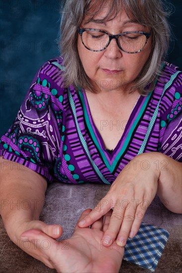 Elderly woman fortune teller reading the lines on a man's hand