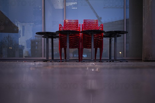 Assembled chairs and tables stand out in front of a closed cafe in Berlin