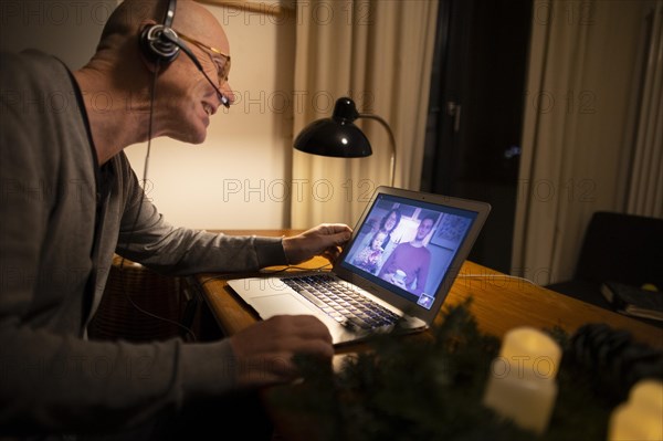 Family at a distance. Man talks to his family at a distance with the help of a webcall.