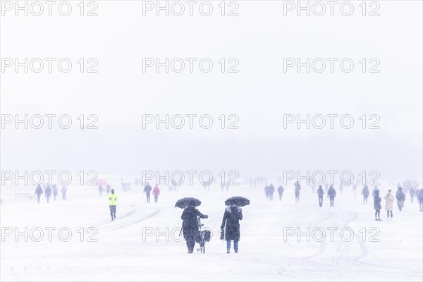 Berliners walk across Tempelhofer Feld in Berlin during snowfall