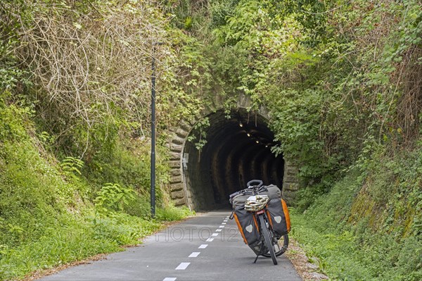 Trekking bike in front of old railway tunnel on the Parenzana cycling trail in Slovenia which runs from Muggia