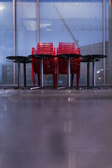 Assembled chairs and tables stand out in front of a closed cafe in Berlin