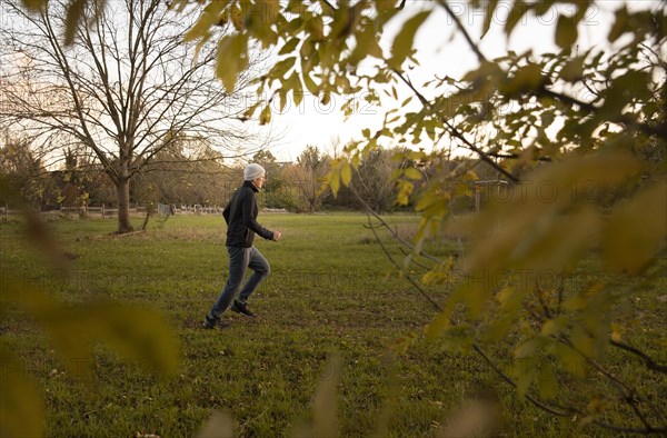 Man doing early morning exercise in autumn in a meadow.