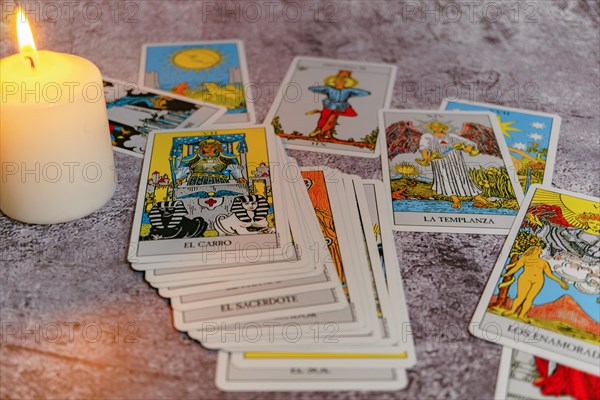 Tarot cards with a lit white candle