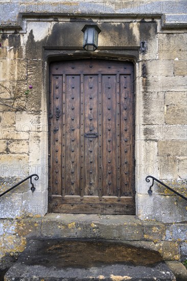 Old wooden front door with staircase in an old stone house