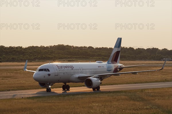 Passenger aircraft Airbus A320-214 of the airline Eurowings in the evening light on the tarmac at Hamburg Airport