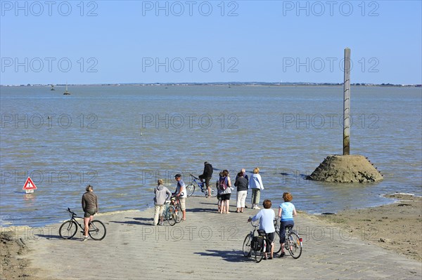 Tourists waiting for low tide to uncover the Passage du Gois