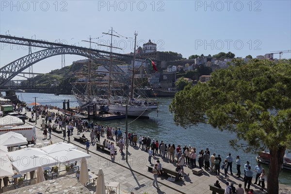 Long queue of people waiting to see the sail training vessel NRP Sagres on the banks of the Douro