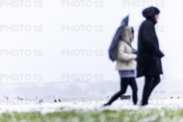 Berliners walk across Tempelhofer Feld in Berlin during snowfall