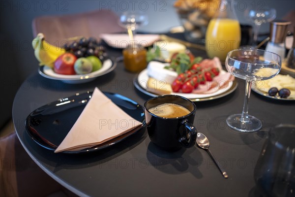 Set dining table with golden cutlery and a cheese and sausage platter