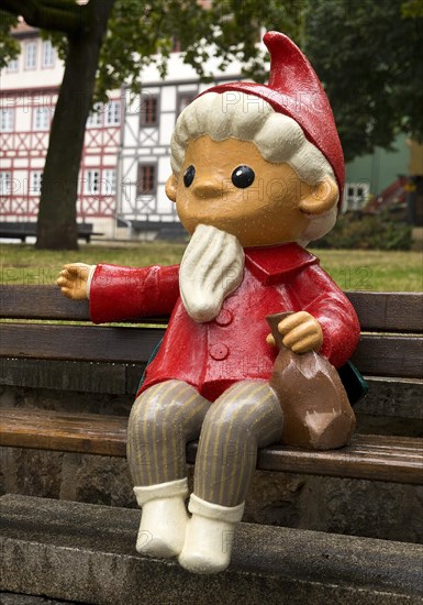 Sculpture of the Sandman on a bench in front of half-timbered houses on Kraemerbruecke in Erfurt