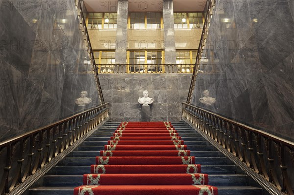 Pompous black marble staircase with red carpet