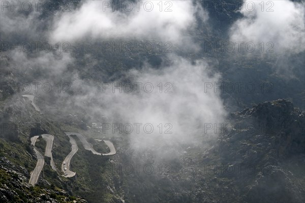 The winding road from Sa Calobra to Coll dels Reis in the Tramuntana Mountains with clouds