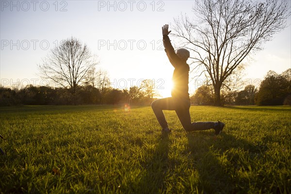 Man stretching in a meadow in autumn. Yoga outdoors.