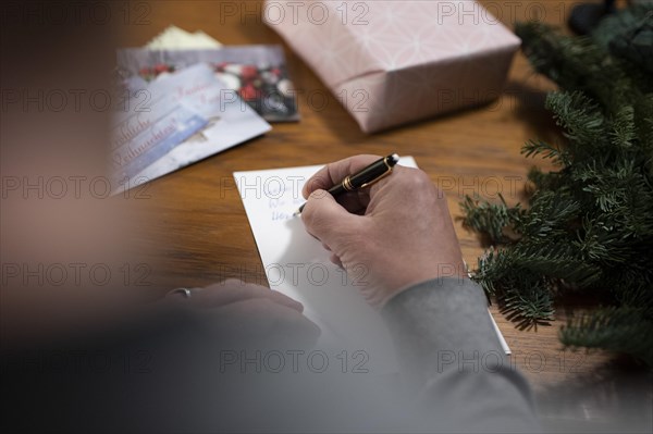 Merry Christmas. Man writes Christmas cards by hand