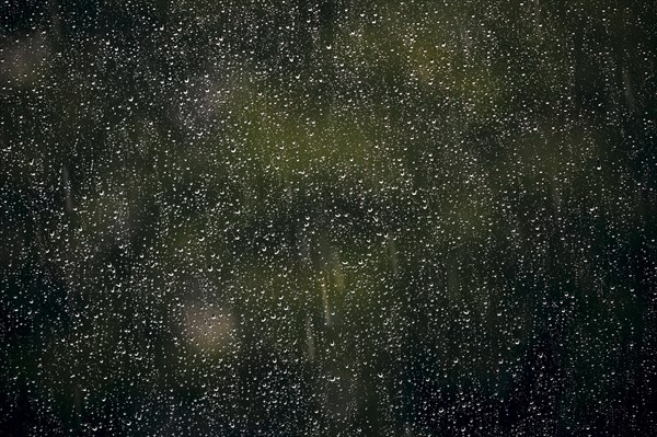 Raindrops hang on a window pane. Berlin