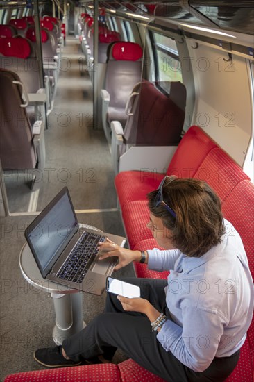 Woman Working on Laptop in First Class in a Train in Switzerland