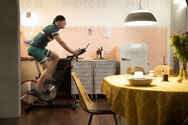 Man on a spinning bike in his kitchen