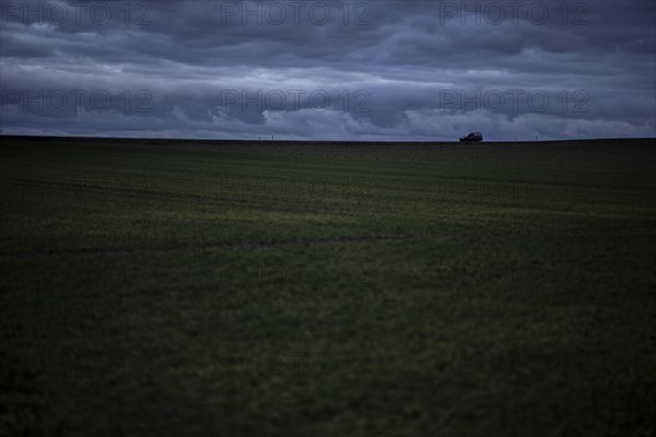 A car stands out on a country road at blue hour in Vierkirchen