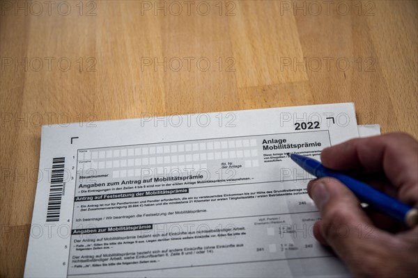 Male hand with biros in front of income tax declaration form