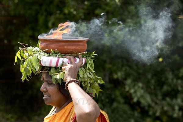 A Hindu woman carries a fire bowl during the big procession Theer