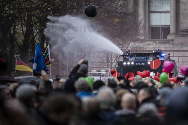 Police officers act with water cannons against demonstrators protesting against the reform of the infection protection law in Berlin