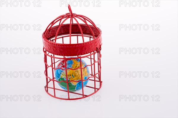 Small globe trapped in a red birdcage