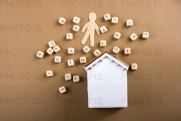 Wooden letter cubes and man figurine and model house