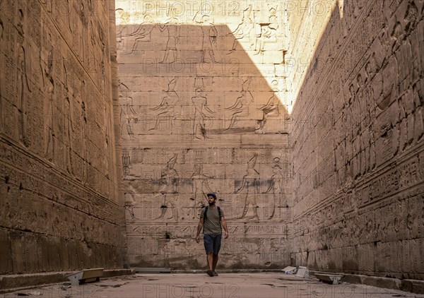A young tourist visiting the beautiful temple of Edfu in the city of Edfu