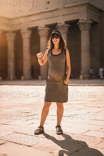 A young tourist wearing a cap visiting the Edfu Temple at sunrise in Aswan. Egypt