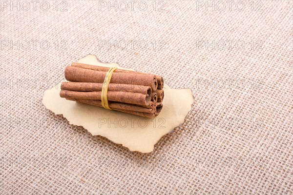 Bundle of cinnamon sticks on a linen canvas background