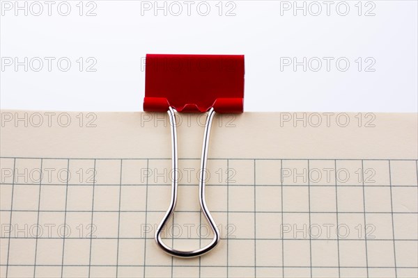 Colored paper clip on a checked notebook page