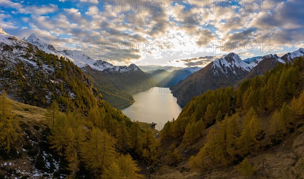 Aerial view at sunset over the autumnal forest at Lago di Luzzone in Valle di Blenio