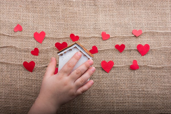 Heart shaped icons and paper house on linen threads