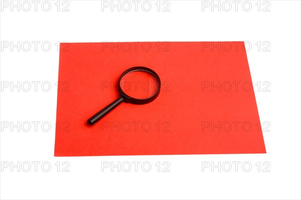 Magnifying glass on a sheet of paper on white background