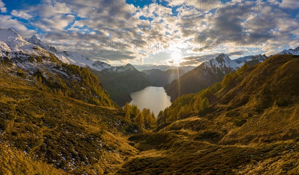 Aerial view at sunset over the autumnal forest at Lago di Luzzone in Valle di Blenio