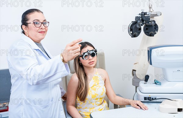 Optometrist assisting patient with optometrist trial frame. Patient with optometrist in a vision test with trial frame