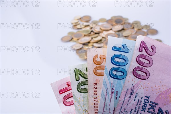 Turkish Lira coins and banknotes side by side on white background