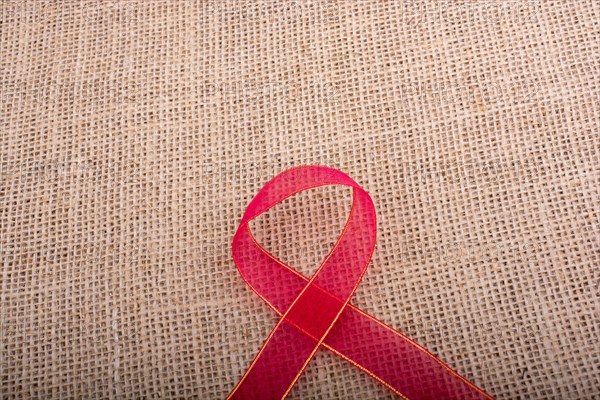 Red band on a brown color linen canvas as a background texture