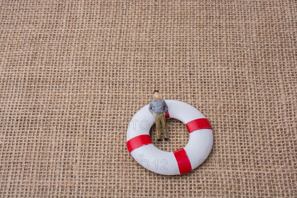 Little figurine man in a life preserver on life on canvas