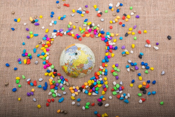 Globe in the heart form shaped by colorful pebbles