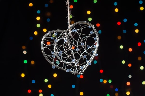 Heart shaped metal cage on a bokeh light background