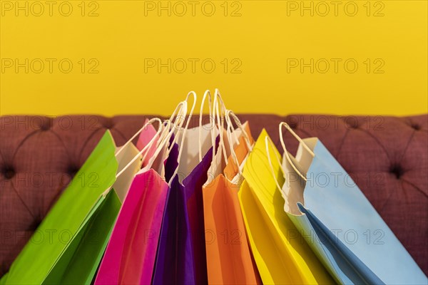 Shopping bags on the sofa. Yellow background. It can be use as a template